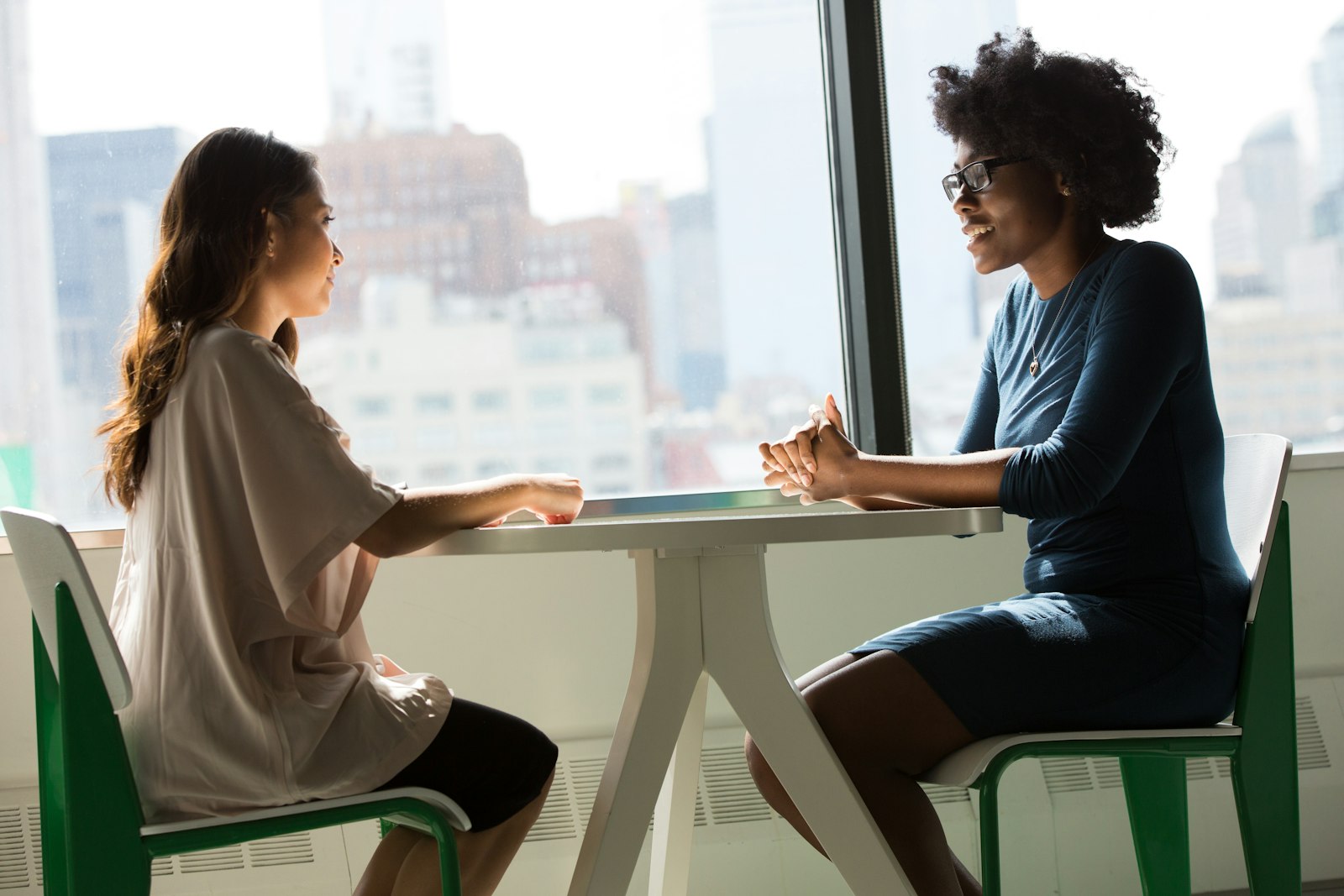 An immigration adviser in conversation with a client at a meeting table
